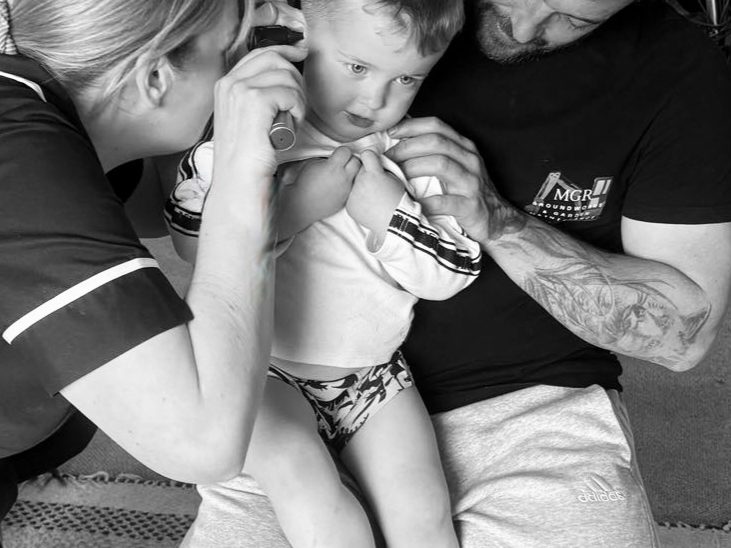 Qualified nurse assessing childs ear. Checking if ear wax removal is necessary.